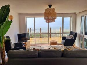 a living room with a couch and a large window at 1Rosemount -Marazion - Iconic view of St Michaels Mt, Sea, Beach, 2xParking, Netflix Prime in Marazion