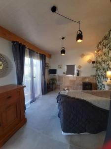 ein Schlafzimmer mit einem Bett und einem großen Fenster in der Unterkunft Gîtes, maisonnette de charme in Crestet