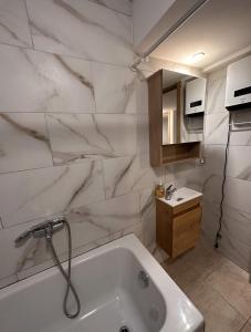 a white bathroom with a tub and a sink at 2 bedroom and kitchen in Mons