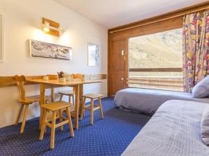 a bedroom with a table and a bed and a window at Studio Les Arcs 2000, 1 pièce, 4 personnes - FR-1-346-462 in Arc 2000