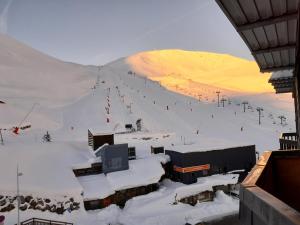 une piste de ski couverte de neige avec une station de ski dans l'établissement Appartement 4 personnes Plat d'Adet - Résidence "Le grand Schuss" - Appt 1208, à Saint-Lary-Soulan