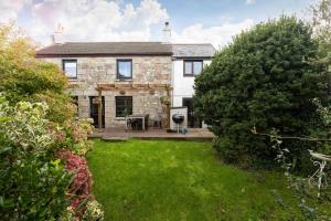 an exterior view of a house with a yard at Traditional Cornish Cottage in the Countryside. in Gwinear