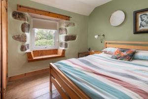 um quarto com uma cama e uma janela em Traditional Cornish Cottage in the Countryside. em Gwinear