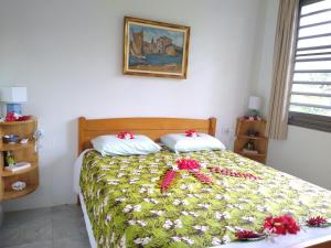 Un dormitorio con una cama con flores. en TAHAA - Fare Motoi en Tiva
