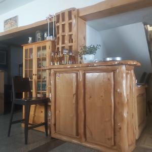 un bancone in legno in una stanza con tavolo e sedia di Ski hotel DOBRODOLAC a Kopaonik