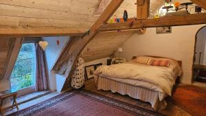 ein Schlafzimmer in einem Blockhaus mit einem Bett darin in der Unterkunft Longère Typique — Charmante chambre d'Hôte 