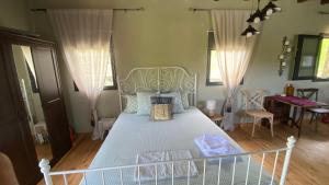 a bedroom with a white bed in a room at Little Garden cabin in Perivolaki