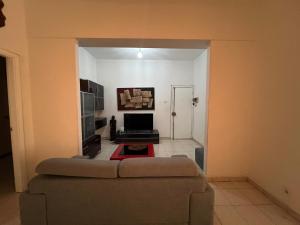 a living room with a couch and a television at África em Zona Comercial de Luanda in Luanda