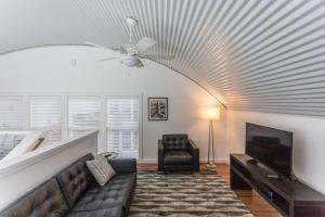 a living room with a couch and a ceiling fan at The Moon Quonset Hut Vacation Rental Heated & Chilled Pool in New Orleans
