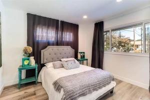 een slaapkamer met een groot bed en 2 tafels bij ৎ୭ Canoga Park View ৎ୭ in Los Angeles