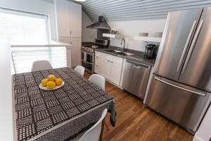 a kitchen with a table with a plate of oranges on it at The Moon Quonset Hut Vacation Rental Heated & Chilled Pool in New Orleans
