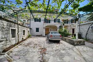 un coche aparcado en el patio de un edificio en Guesthouse Anita, en Kotor