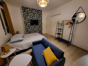 uma sala de estar com uma cama e um sofá azul em Deguise 9 em Valenciennes