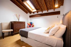 um quarto com uma cama com uma cadeira e uma cómoda em Casa Olivera em Denia