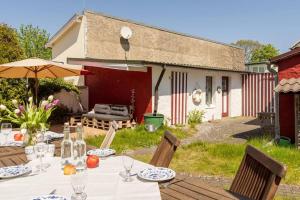 a table with chairs and an umbrella in a yard at Ferienhaus Koserow, Usedom, 8 Pers., Hunde erlaubt in Ostseebad Koserow