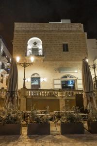 a building with tables and umbrellas in front of it at DOMS Boutique Living in Mellieħa