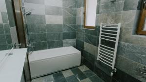 a bathroom with a shower and a white bath tub at Keystone residences in Kolašin +12 photos