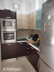 eine Küche mit braunen Schränken und einem Kühlschrank aus Edelstahl in der Unterkunft Stella Luxury Apartment Kalathos in Kalathos + 32 Fotos