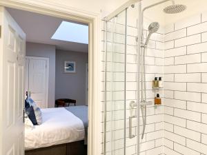 uma casa de banho com chuveiro e uma cama num quarto em Beach House Hotel em Seahouses