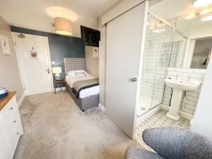 y baño con cama, lavabo y ducha. en Beach House Hotel, en Seahouses