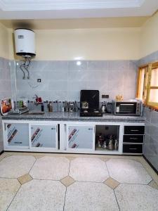 a kitchen with a white counter and a microwave at Residence Adnan luxury Appartments in Ouarzazate