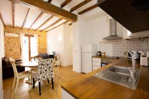 een keuken met een wastafel en een tafel met stoelen bij Casa Olivera in Denia