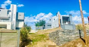 un bâtiment avec une clôture devant lui dans l'établissement Lofts en la Sierra!!, à Villa Carlos Paz