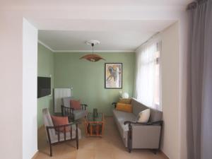 uma sala de estar com um sofá, cadeiras e uma mesa em Garden House Retreat em Drama