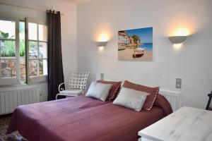 a bedroom with a bed and a chair and a window at La Casa Celestial in Platja d'Aro