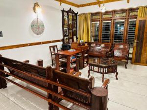 a room with wooden benches and tables and windows at Farm Fort Resort By Luxdens Hotels in Kozhikode