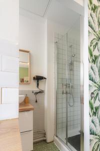 La salle de bains est pourvue d'une douche avec une porte en verre. dans l'établissement LE REFUGE - NETFLIX I WIFI HAUT DEBIT I PARKING - Confort & Cosy, à Valenciennes