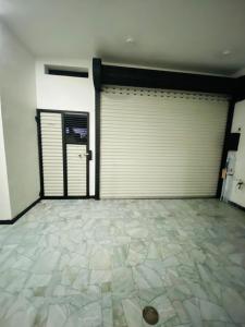 un garaje vacío con 2 puertas y suelo de baldosa en Minuki guest house, en Weligama