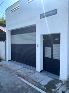 dos puertas de garaje en el lateral de un edificio en Minuki guest house, en Weligama