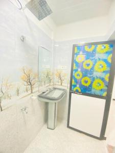 un baño con lavabo y una pintura en la pared en Minuki guest house, en Weligama