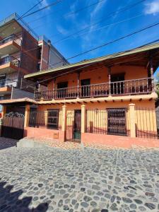 un edificio con un balcón en el lateral. en Hostal La Pola, en Santa Fe de Antioquia