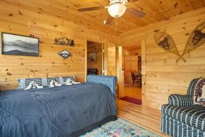 1 dormitorio con 1 cama y 2 sillas en una cabaña en Dream Weaver Cabin en Candler