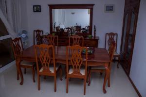 uma mesa de jantar em madeira com cadeiras e um espelho em Casa Ramos Castro em Mindelo
