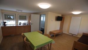 a kitchen with a table with a green table cloth on it at Feriendorf am Flämingbad Bungalow Nummer 23 in Coswig