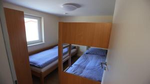 um pequeno quarto com 2 camas e uma janela em Feriendorf am Flämingbad Bungalow Nummer 23 em Coswig