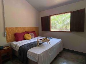 a bedroom with a large bed with a window at Chalés Pocoó com rio exclusivo in Bonito