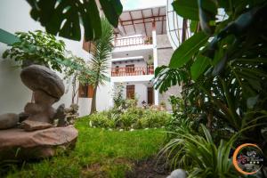 a garden with a stone statue in front of a building at El Cumbe Inn in Cajamarca