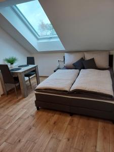 a bedroom with a bed and a desk and a skylight at Bianca's Ferienwohnungen in Giebelstadt