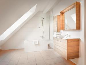 baño blanco con ducha y lavamanos en SKY9 Penthouse Apartments, en Viena