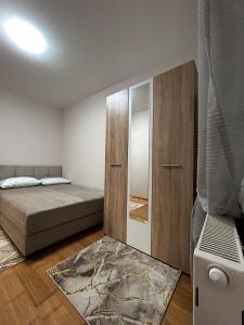 een slaapkamer met een bed, een kast en een tapijt bij Apartman S Pale in Pale