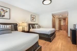 two beds in a room with wooden floors at Lodge at 100 W Beaver Creek Blvd #2 - 401 in Avon
