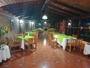 a restaurant with tables and chairs with green tablecloths at Plaza Don Gabino Hotel y Restaurante in Mineral de Angangueo