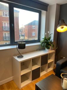 a living room with a window and a white shelf at City Centre Modern Studio Apartment - Westone FREE WIFI, GYM ACCESS, NETFLIX in Sheffield