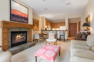 a living room with a fireplace and a kitchen at Lodge at Brookside 105 in Edwards