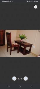 a table and a chair with a plant on it at PrimeRose Hotel Mubende in Mubende