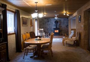 una sala da pranzo con tavolo e camino di The Nest in the Forest Bed and Breakfast (Hot tub and Sauna) a Lakefield